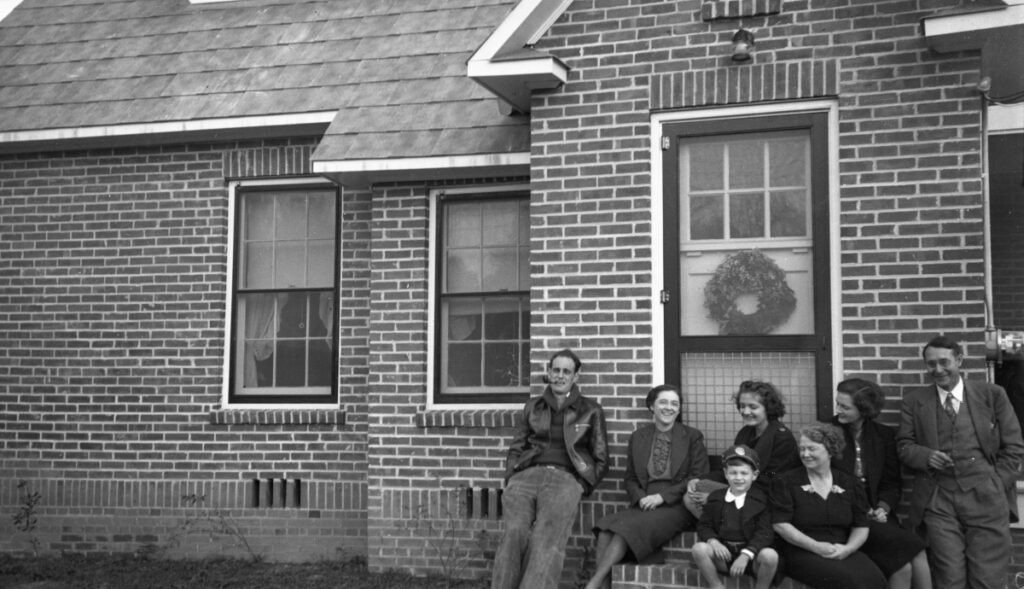 This black and white photo taken Jan. 1, 1940, shows members of the Dixon, Peavy and Akerman families on the stoop in front of a one-story brick house built in 1930.