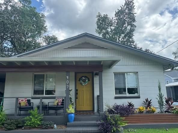 This white bungalow has a bright yellow door.